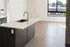 Modern apartment interior showcasing an elegant kitchen island with a sleek sink, complemented by large windows and natural light on exquisite wood flooring.
