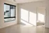 Bright and inviting room with large window showcasing natural light and sleek hardwood floors, next to a cozy carpeted space.