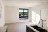 Bright, contemporary apartment interior featuring large windows with scenic views, sleek kitchen countertops, and modern fixtures.