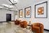 Modern apartment lobby featuring chic orange velvet armchairs, eye-catching abstract art, and sleek lighting fixtures.