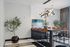 Elegant dining area with modern lighting, chic wooden chairs, and lush green plants creating a sophisticated ambiance.