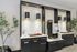 Elegant coffee station in modern apartment lobby featuring sleek black cabinetry, stylish lighting, and lush greenery.