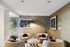 Elegant living room with plush beige chairs, modern art, and soft lighting, perfect for relaxation and social gatherings.