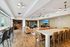 Spacious and modern open-concept living area with elegant wood flooring, sleek leather seating, and expansive windows offering natural light.