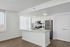 Modern kitchen with sleek white cabinetry, stainless steel appliances, and elegant wood flooring, offering a bright and inviting space for culinary creativity.