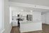 Sleek modern kitchen with white cabinetry, stainless steel appliances, and a spacious island countertop, perfect for entertaining.