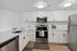 Modern kitchen with sleek stainless steel appliances, chic white cabinets, and elegant countertops.