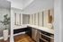 Modern kitchen with sleek stainless steel appliances, elegant white countertops, and stylish tile backsplash, complemented by warm wood flooring and decorative plants.