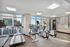 Modern fitness center with state-of-the-art treadmills and exercise machines, featuring large windows with scenic views.