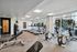Bright, modern fitness center featuring various exercise machines and large windows offering natural light.
