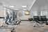 Bright and modern fitness center with cardio machines, free weights, and floor-to-ceiling mirrors, perfect for an invigorating workout.