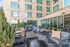 Chic outdoor lounge with modern furniture and warm string lights, creating a cozy ambiance against a stylish apartment backdrop.