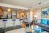 Modern open-concept living area with a sleek kitchen, stylish bar stools, and contemporary artwork, perfect for urban living.