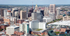 Vibrant aerial view of a bustling cityscape featuring diverse architecture, modern skyscrapers, and scenic greenery.