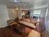 Modern open-concept living space with elegant hardwood floors, featuring a cozy seating area, stylish dining set, and a fully-equipped kitchen with wooden cabinetry.