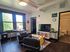 Contemporary living room with large windows, stylish seating, and modern decor, perfect for cozy gatherings.