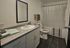 Modern, inviting bathroom with sleek countertop, elegant fixtures, and a pristine bathtub with a stylish shower curtain.