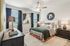 furnished primary bedroom with windows and ceiling fan