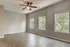 Bright and airy room with large windows, modern ceiling fan, and elegant wood flooring, perfect for a serene living space.
