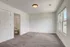 Bright and airy bedroom with plush carpet, large windows offering natural light, and an ensuite bathroom for modern comfort.