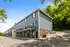 Charming modern apartment complex with blue siding, wooden balconies, and scenic tree-lined surroundings.