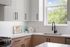 Sleek modern kitchen with bright white cabinetry, elegant black fixtures, and a scenic window view.