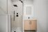 Sleek modern bathroom featuring a glass-enclosed rainfall shower, elegant vanity with illuminated mirror, and minimalist fixtures.