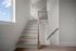Bright modern staircase with elegant wooden steps and natural light from a large window.