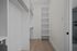 Elegant walk-in closet featuring sleek shelving and ample hanging space with modern design.