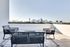 Elegant outdoor terrace with modern seating offering a breathtaking city skyline view.