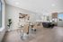 Bright and modern open-concept dining area with chic kitchen, stylish pendant lighting, and large windows enhancing the spacious layout.