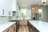 Modern kitchen with sleek white cabinets, stainless steel appliances, and expansive quartz countertops.