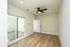 Bright, modern room featuring sleek hardwood floors, an elegant ceiling fan, and large sliding glass doors leading to a private outdoor space.