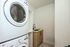 Modern laundry room with sleek stacked washer and dryer, featuring a stylish sink with contemporary faucet design.
