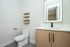 Modern bathroom with sleek design featuring a stylish vanity, illuminated mirror, and minimalistic decor for an elegant touch.