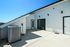 Spacious modern patio with sleek white walls, large sliding glass doors, and scenic views, perfect for relaxation and entertaining.