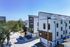 Modern multi-story townhouses with sleek design and large windows, nestled in a serene urban neighborhood.