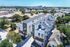 Modern multi-story apartment complex with sleek design surrounded by lush greenery, offering vibrant urban living.