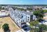 Contemporary multi-story apartment complex surrounded by lush greenery and urban skyline views.