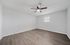 Spacious, bright room with sleek wood flooring and modern ceiling fan, ideal for a cozy living space.
