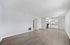 Bright and airy open-concept living space with stylish laminate floors, modern white kitchen cabinets, and ample natural light.