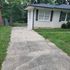 Charming house exterior with inviting pathway and lush greenery, perfect for creating lasting memories.
