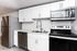 Modern kitchen with sleek stainless steel appliances, white cabinetry, and elegant subway tile backsplash.