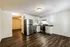 Modern kitchen with stainless steel appliances and elegant wood flooring.