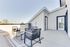Chic apartment terrace with modern outdoor seating, offering stunning city views and plenty of natural light.