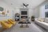 Modern living room with sleek fireplace, cozy beige sofa, and stylish yellow chairs offering a warm, inviting atmosphere.