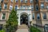 Charming historic apartment building with elegant brick facade and grand entrance, adorned with greenery and decorative architectural details.