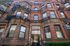 Charming brick apartment building with elegant architectural details and Juliet balconies, offering urban living experience.