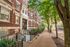 Charming brick apartment building with classic architecture on a tree-lined street, offering urban living with a touch of historic elegance.