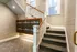 Elegant apartment staircase with ornate railing and modern postal lockers in a well-lit entryway.